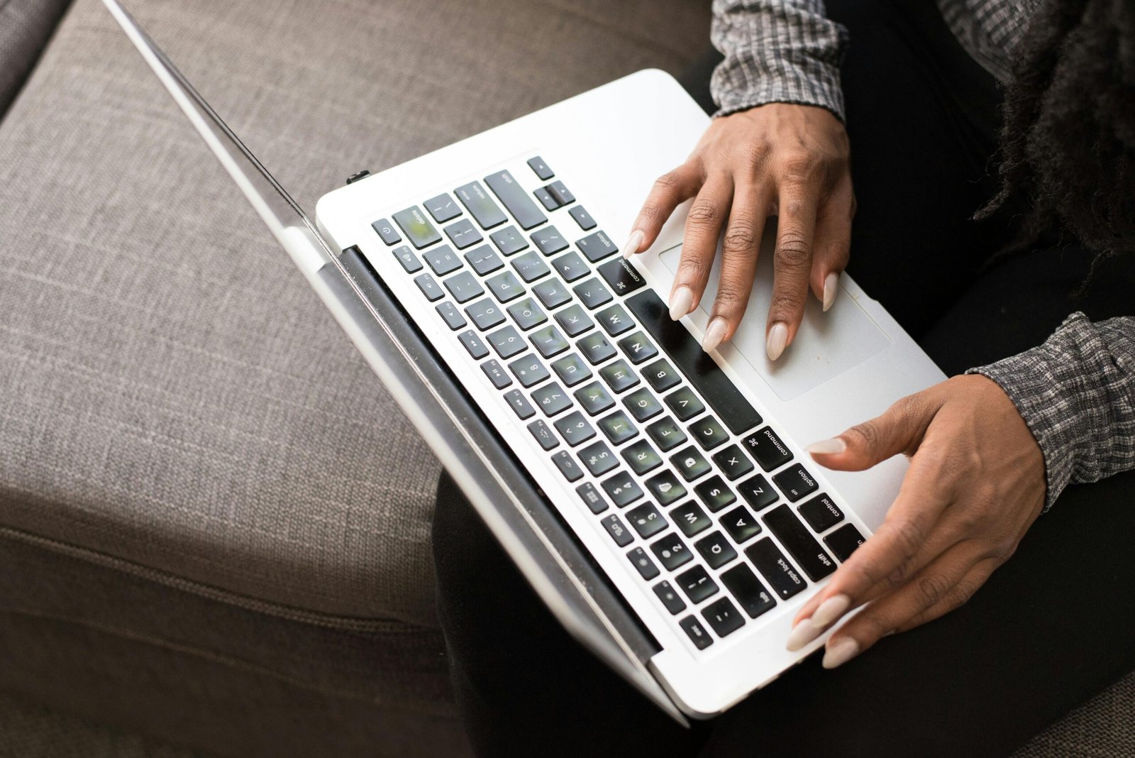 A woman typing on a laptop keyboard, focused on productivity and technology.